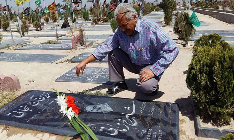 A photo of Mohammad Jarrahi visiting the grave of fellow labor activist Shahrokh Zamani, who died of a stroke in September 2015 after being denied medical care as a political prisoner.