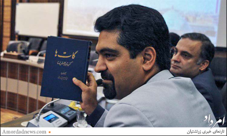 Yazd city councilman Sepanta Niknam holds up a book called Ghathas, the 17 Avestan hymns of the Zoroastrian religion, during a council meeting.